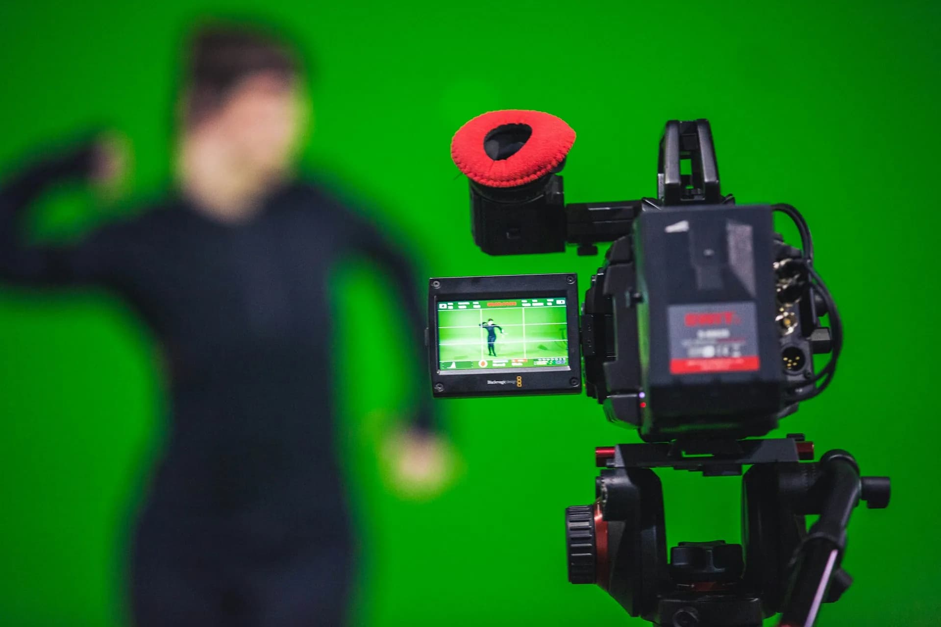 Cámara de vídeo grabando a una persona delante de un fondo verde de croma key en estudio